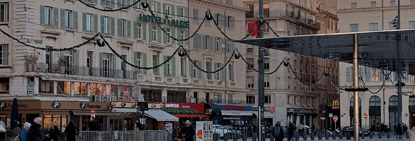 kaupunkinäkymä Marseillessa, aukiolla ihmisiä ja taustalla kerrostaloja